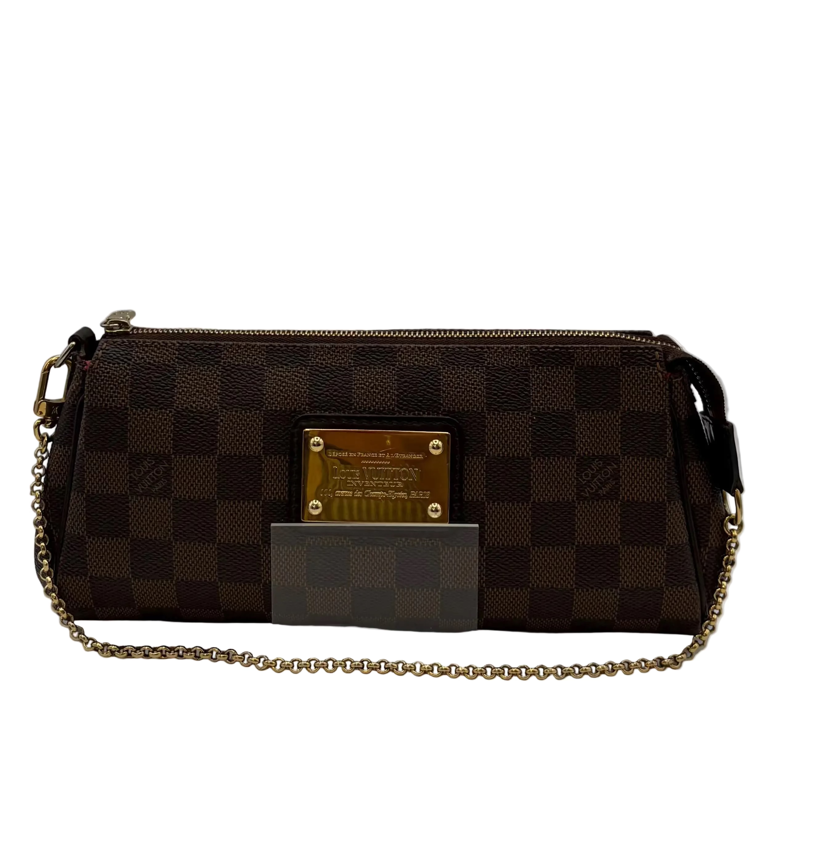 A Louis Vuitton shoulder bag in the Damier Ebene checkered canvas, featuring a gold-tone metal plaque on the front and a gold-tone chain strap, displayed on a clear acrylic stand.
